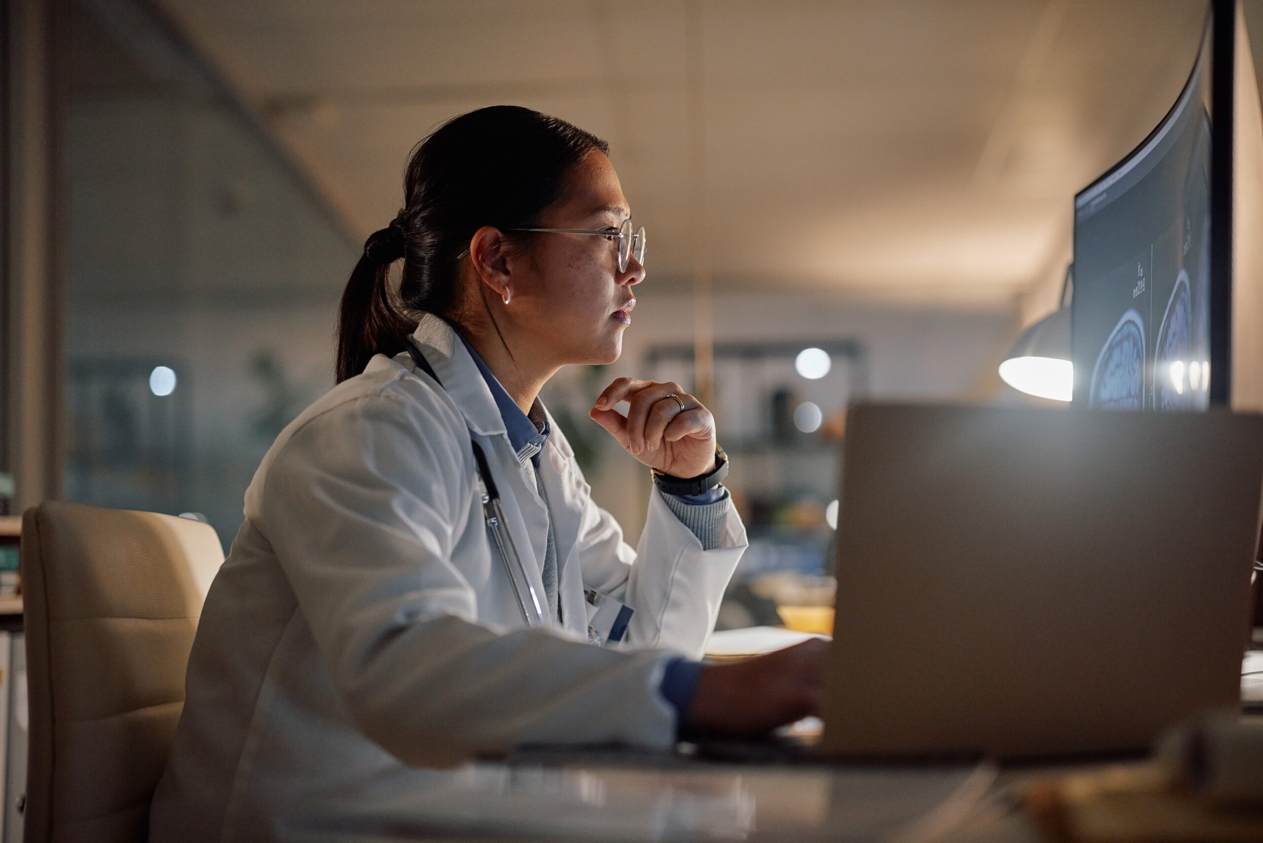 Woman looking at computer in lab coat